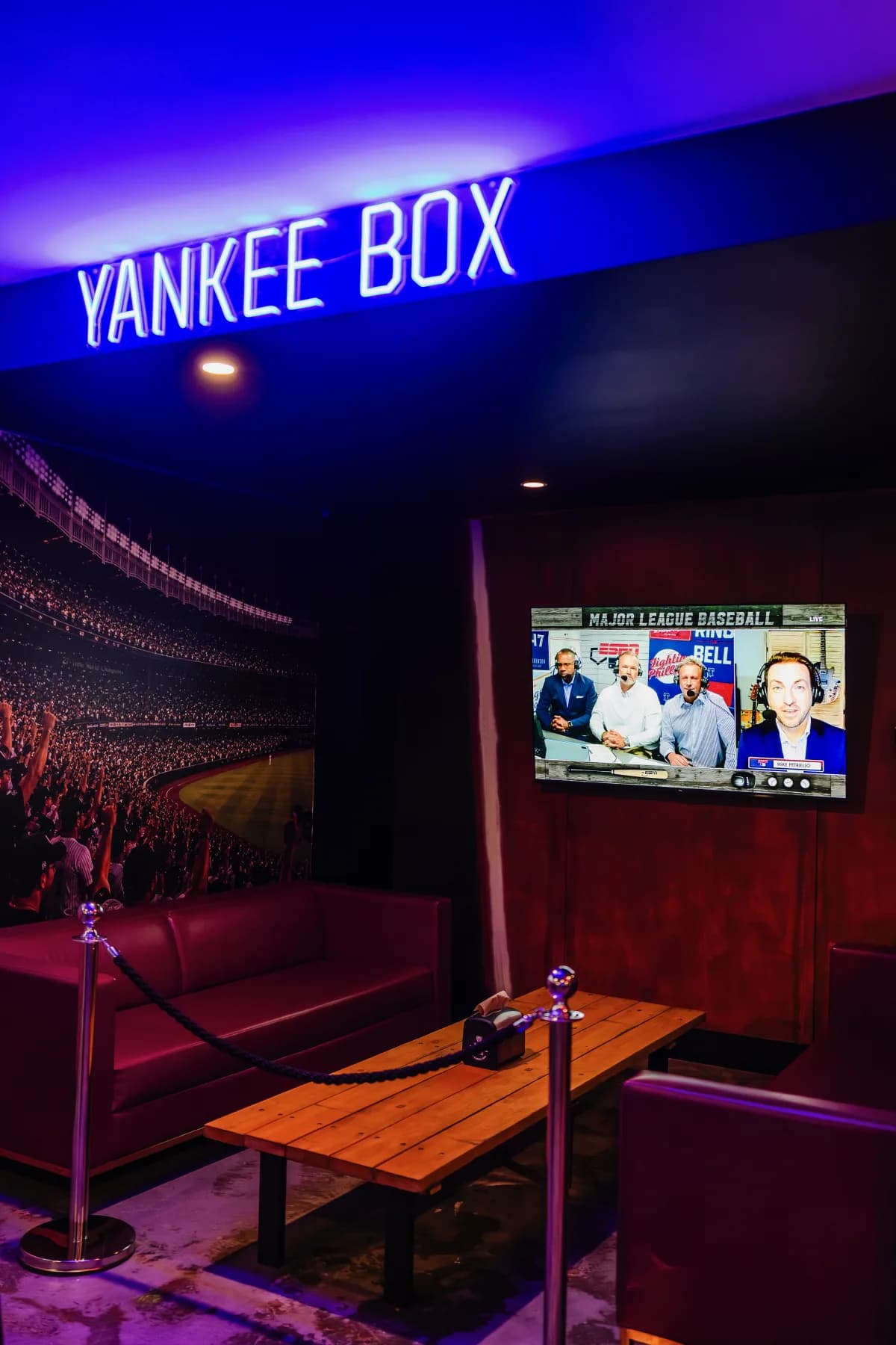 Private Yankee Box with red lounge seating, timber tables and dedicated sports screen